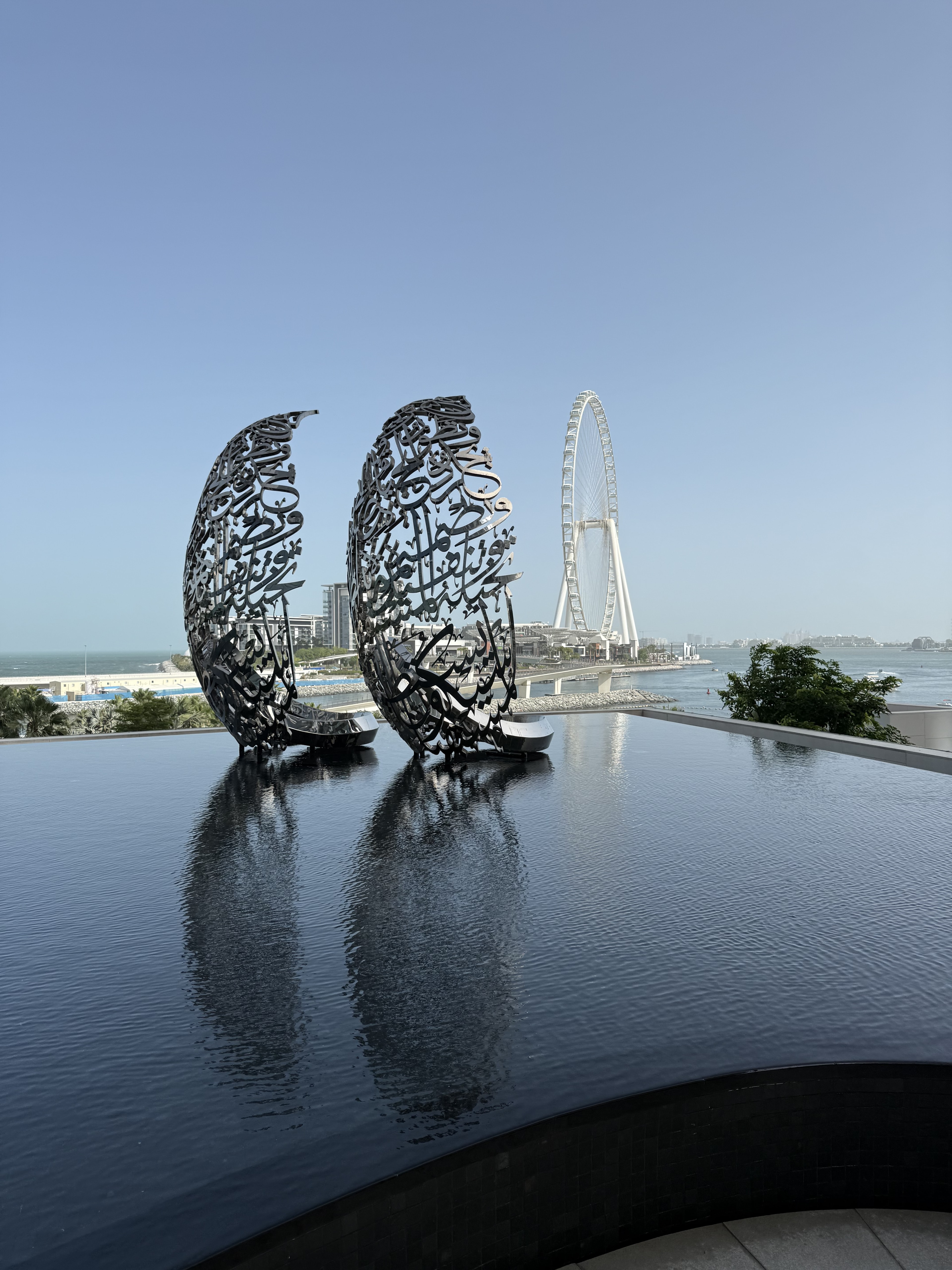 Calligraphy sculptures by an infinity pool facing Ain Dubai at Bluewaters